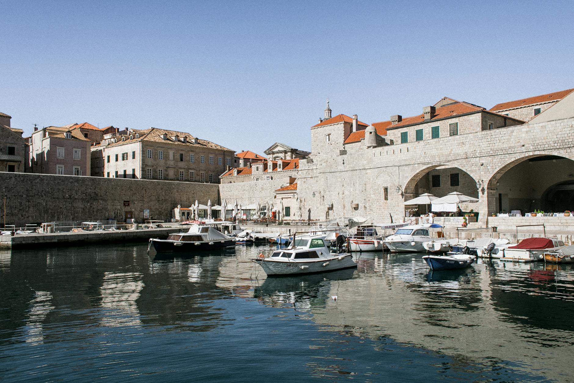 Vacation In Dubrovnik On A Budget old city port with motor boats on sea